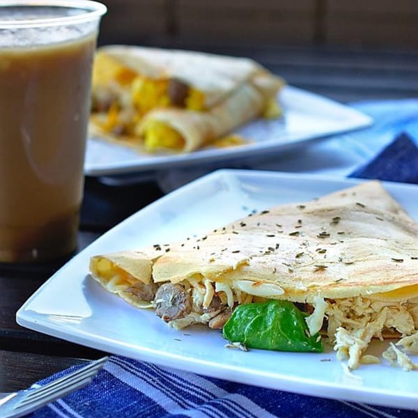 Savory crepes filled with chicken, mushrooms, and cheese, served with a drink.